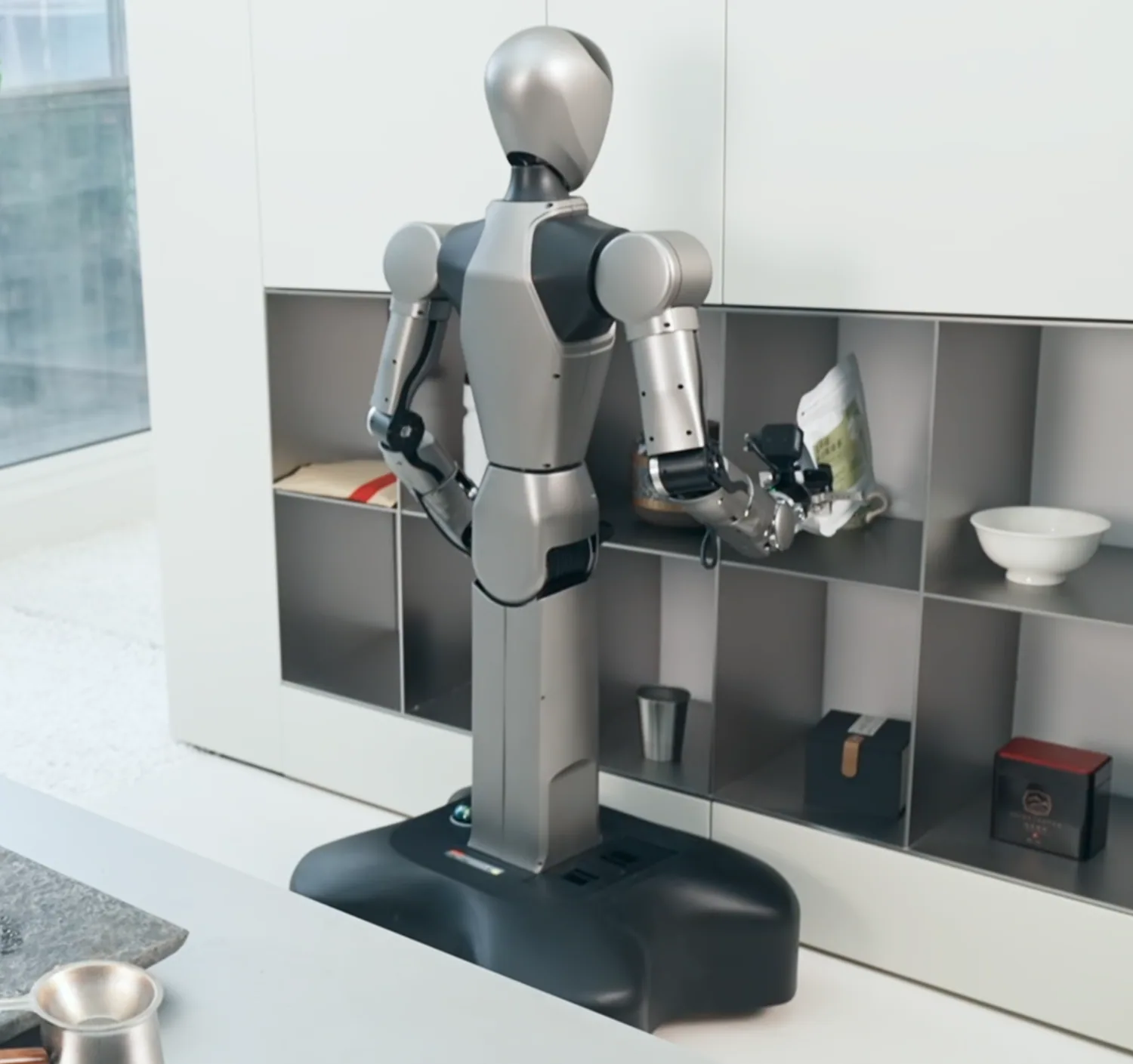HUMANOID ROBOT assisting with objects on a kitchen countertop.