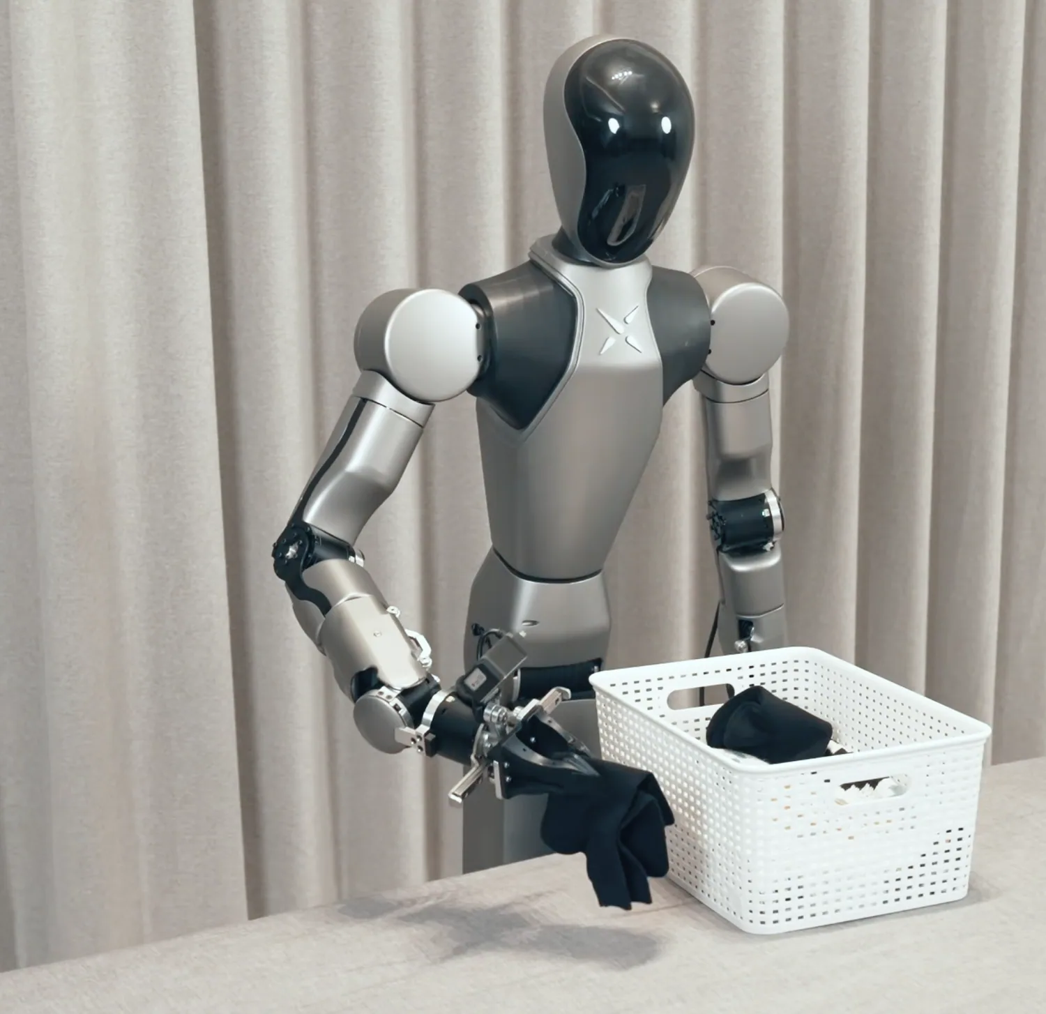 HUMANOID ROBOT handling laundry beside a basket.